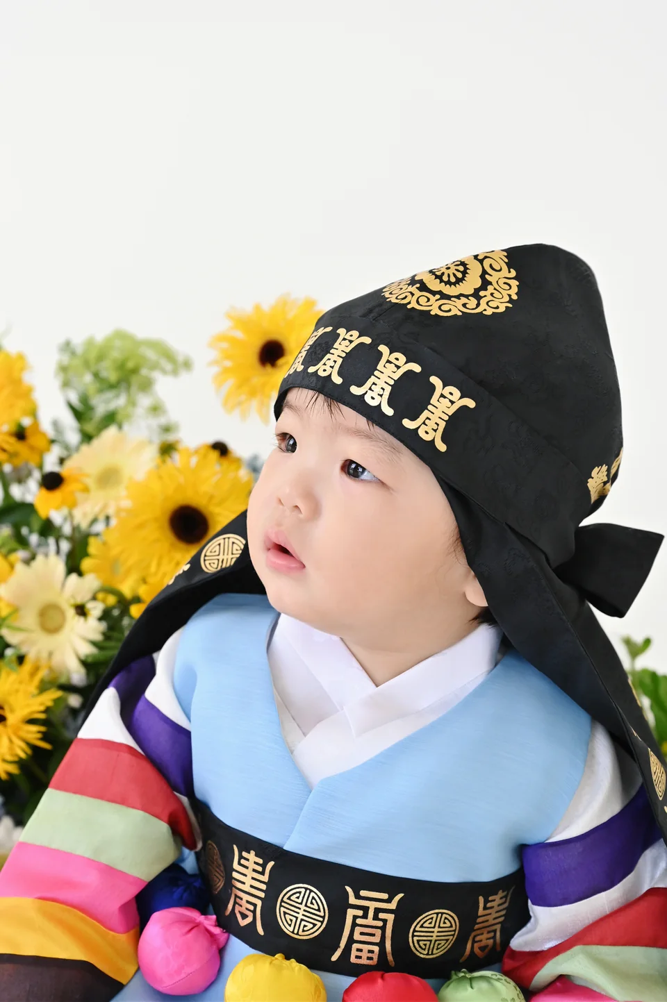 검은 전통 모자를 쓰고 옆을 바라보는 도하의 얼굴