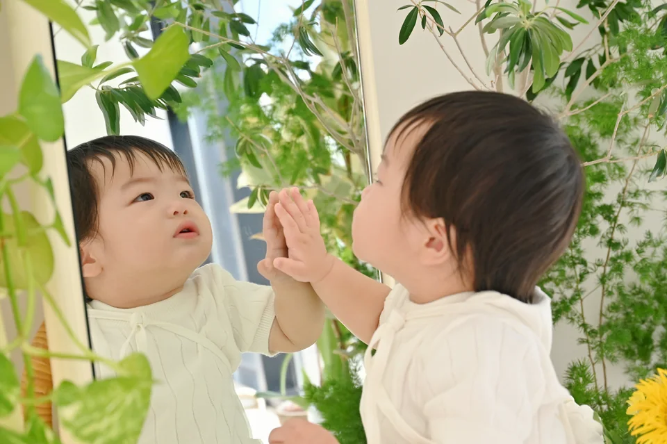 흰 옷 차림으로 거울 속 자기 모습에 손을 대는 도하