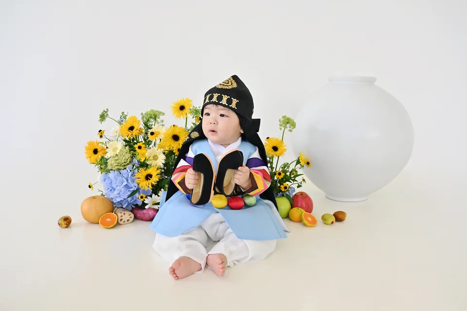 자리에 앉아 검은 신발을 손에 든 한복 차림의 도하